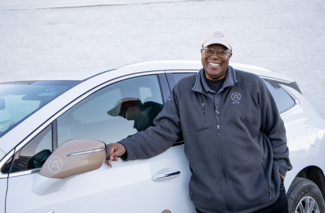 Alto driver standing next to card